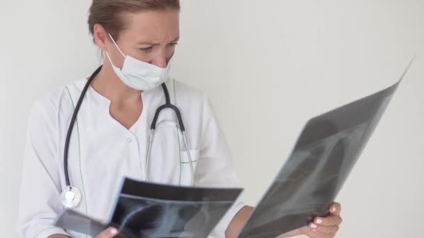 Μια γυναίκα γιατρός εξετάζει ακτίνες Χ των πνευμόνων με πνευμονία — Αρχείο Βίντεο