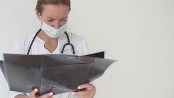 Μια όμορφη γυναίκα γιατρός εξετάζει ακτίνες Χ των ασθενών με πνευμονοπάθεια-19 — Αρχείο Βίντεο