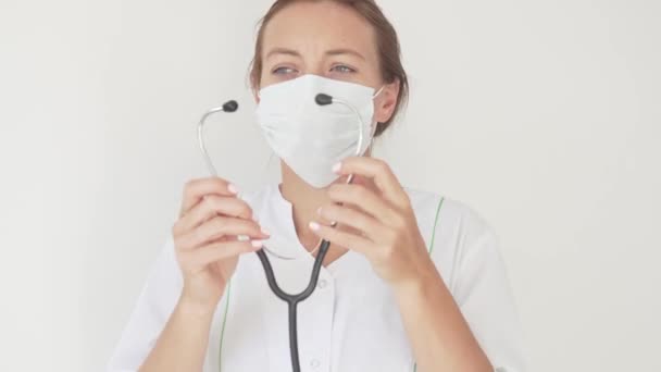 A beautiful female doctor in a medical mask with a stethoscope — Stock Video