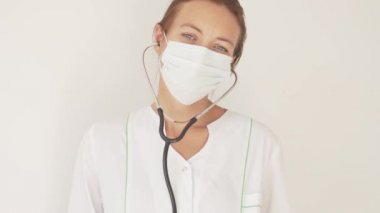 Güzel bir kadın doktor yüzündeki tıbbi maskeyi çıkarıyor.