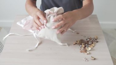 Bir kadın kostüm için şık bir çantaya kokulu kuru çiçekler koyar.
