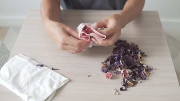 Женщина пакует подушку с ароматами для одежды — стоковое видео