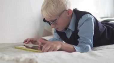 Okçuluktaki öğrenci evde tablet oynuyor.