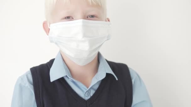 Close-up of a beautiful schoolboy boy in a medical mask — Stock Video