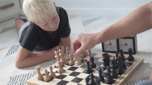 Chlapec hraje doma šachy se svým tátou — Stock video