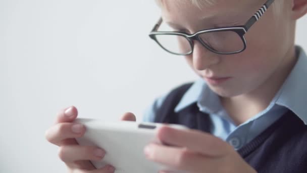 Gros plan portrait de garçon avec des lunettes jouer jeu mobile — Video