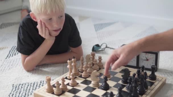 Papa bringt dem halbwüchsigen Sohn das Schachspielen bei. — Stockvideo