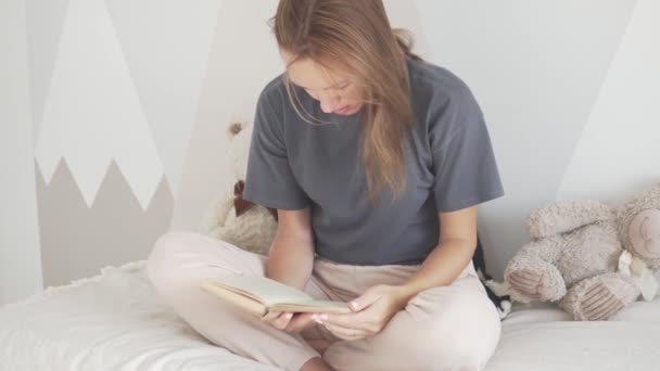 Krásná žena čte knihu na posteli — Stock video