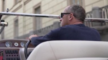 Arkadan bakınca, adam zevk teknesini kontrol ediyor.