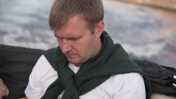 A brooding man floats on a speedboat on the river — Stock Video