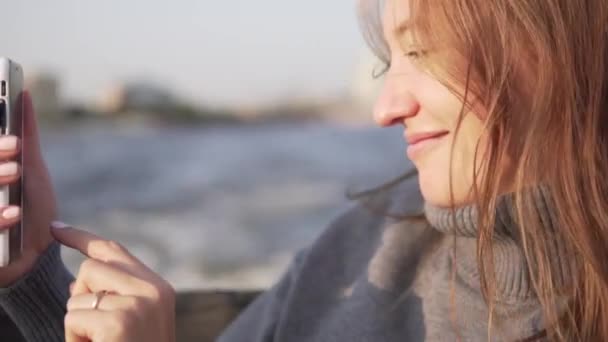 Krásná žena plave na lodích přes kanály Petrohradu a vezme selfie na telefonu — Stock video