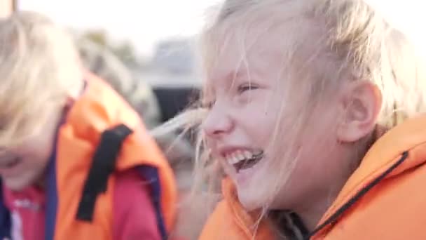 Graciosa niña en un chaleco salvavidas monta en una lancha rápida. — Vídeos de Stock