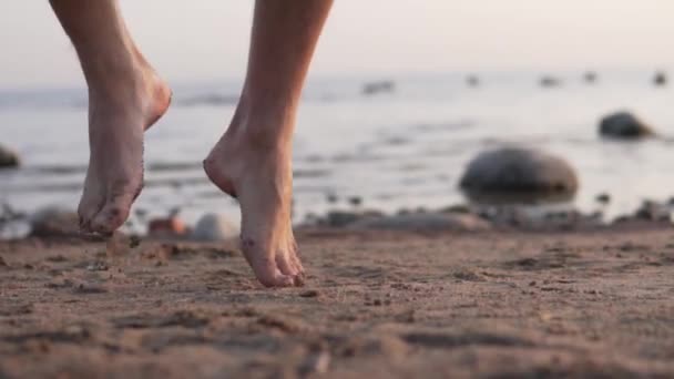 Босоногі чоловічі ноги танцюють на піску біля моря — стокове відео