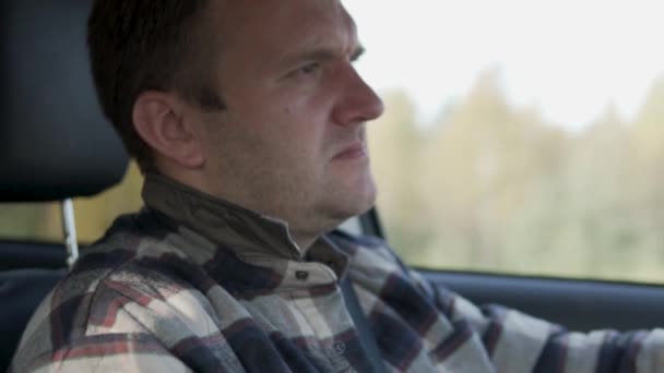 Un homme conduit une voiture un jour d'automne ensoleillé — Video