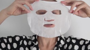 Bir kadın evin yüzüyle ilgilenmek için bez bir maske yapar.