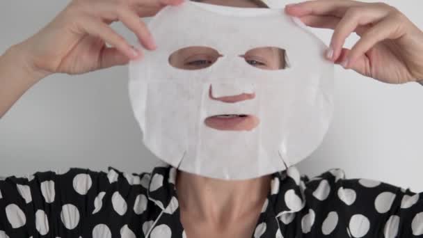 Eine Frau fertigt eine Stoffmaske an, um das Gesicht des Hauses zu pflegen — Stockvideo