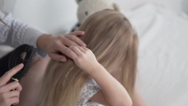Mamá peina el pelo de las hijas pequeñas pelo largo y rubio en la mañana — Vídeo de stock