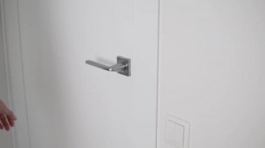 Kadınların eli, kapı kolunun yanındaki odaların kapısını açar.