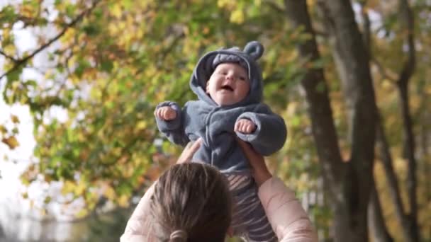 Woman cheerfully plays with toddler on a walk in the fall — Stock Video