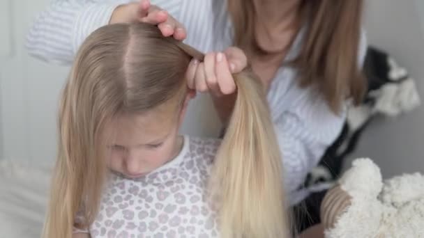 Mutter flechtet der kleinen Tochter des Hauses den Schwanz — Stockvideo