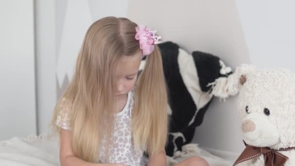 A cute little girl combs her hair with a comb — Stock Video