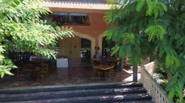 September 15, 2025, Spain, Elche, home of Sicily winery. Friends sitting at a table at the entrance of a winery tasting wine, Harvest Season.