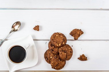 Geleneksel çikolatalı kurabiye ve kahve Beyaz ahşap masa üzerinde