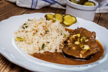 Çek geleneksel gıda Znojmo'nın sos Kornişon ve domuz eti ve ahşap masa pirinç ile