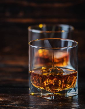 Alkol içki viski, viski ya da viski koyu ahşap masa buz küpleri ile