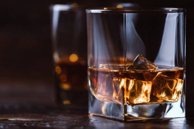 Alkol içki viski, viski ya da viski koyu ahşap masa buz küpleri ile