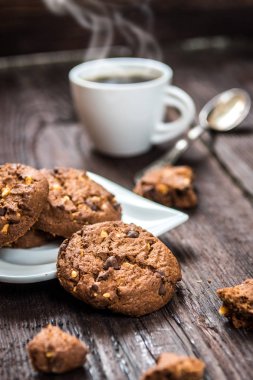Ahşap masa kahve ile geleneksel çikolatalı kurabiye