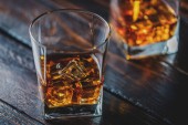 Alkohol pít whisky, whisky nebo bourbon s ledem na tmavé dřevo stůl