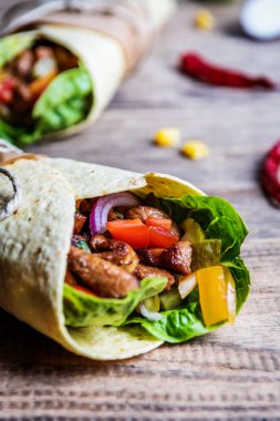 Geleneksel Meksika tortilla şal ahşap masa üzerinde ızgara tavuk eti ve sebze ile