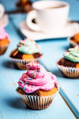 Renkli pembe ve yeşil mavi masada krema ile çikolatalı kek