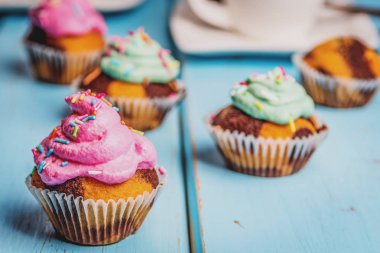 Renkli pembe ve yeşil mavi masada krema ile çikolatalı kek