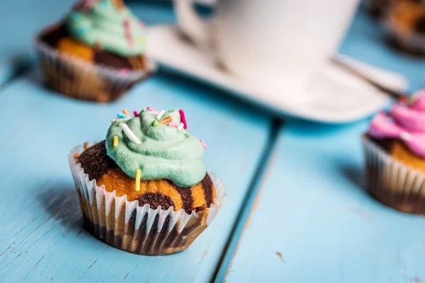 Chocolade Cupcake Met Gekleurde Roze Groen Crème Blauwe Tafel — Stockfoto