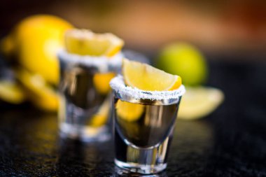 Geleneksel Meksika tekila karanlık taş tablo tablo limon, tuz ve buz küpü ile