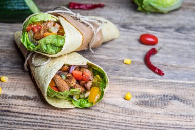 Geleneksel Meksika tortilla şal ahşap masa üzerinde ızgara tavuk eti ve sebze ile