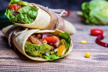 Geleneksel Meksika tortilla şal ahşap masa üzerinde ızgara tavuk eti ve sebze ile