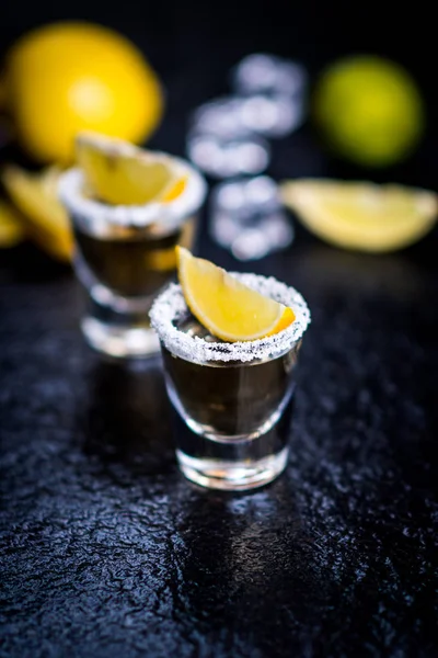 墨西哥传统龙舌兰酒与柠檬 盐和冰块在黑暗的石头桌上 — 图库照片