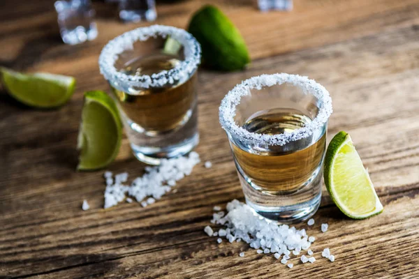 墨西哥传统酒精饮料龙舌兰酒与石灰和盐和冰块在木桌上 — 图库照片