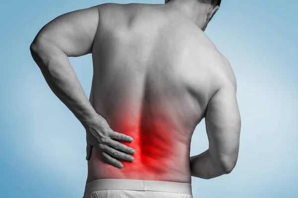 Мускулистый человек с болью в спине — стоковое фото