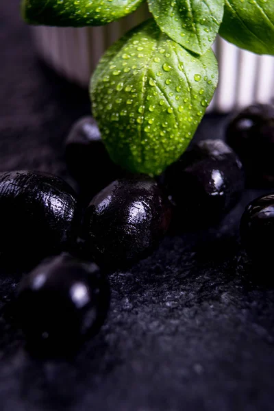 Black olives on black stone — Stock Photo, Image