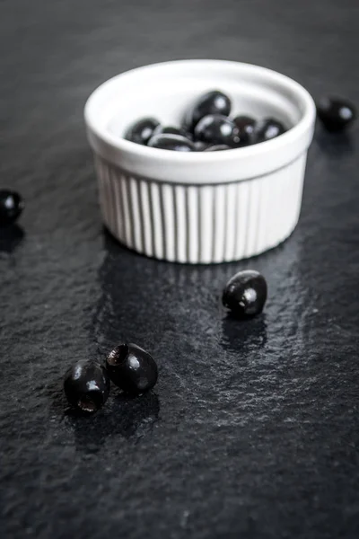 Black olives on black stone — Stock Photo, Image