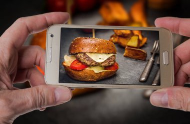 Adam sığır eti ile Cheeseburger fotoğraf çekmek