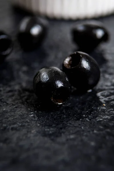 Černé olivy na černém kameni — Stock fotografie