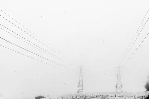 Visa Kraftledningar Som Passerar Genom Snöiga Mist — Stockfoto