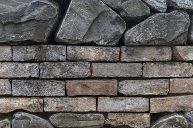 Taşlardan ve tuğlalardan oluşan eski gri bir duvar. Boşluğu kopyala