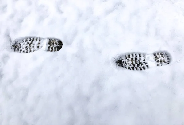 Footprints on the white snowy road. Nobody. Human footprint. Climate change concept