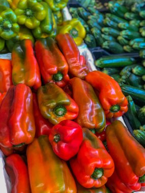 Taze kırmızı ve sarı biberler markette diğer sebzelere yakın plan çekimde. Organik yiyecekler. Salata malzemeleri. Fiş..  